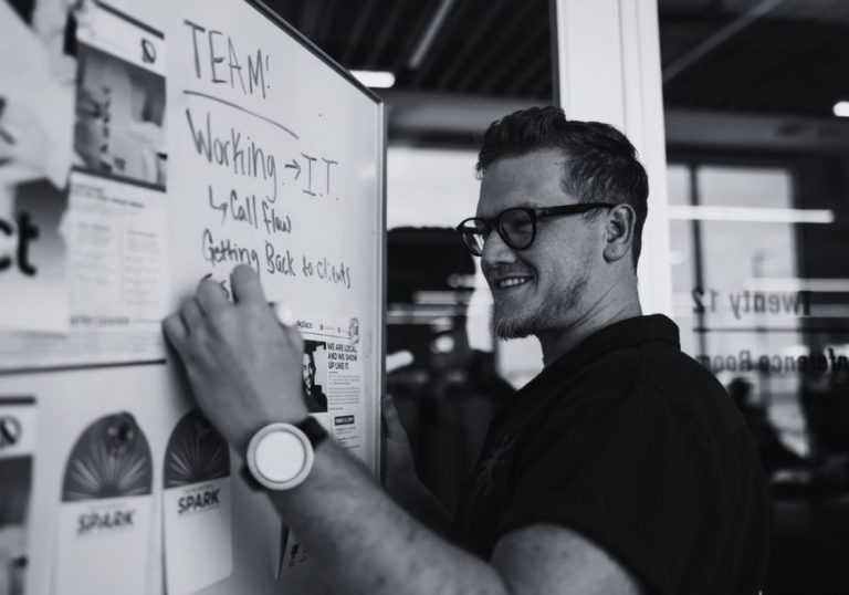 IT professional planning technology and security strategy on a whiteboard