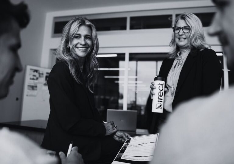 Two team members discussing business technology planning during an office meeting.