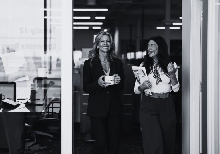 Business professionals having a conversation in a modern office environment.