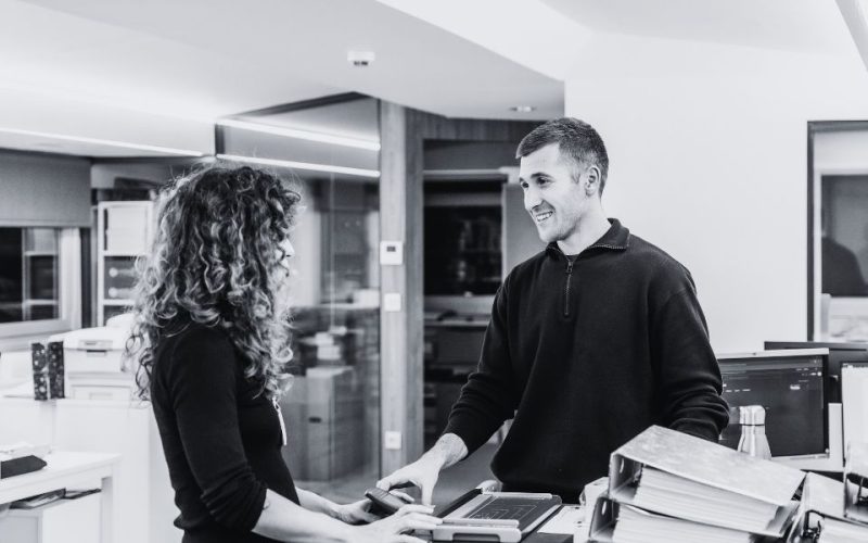 Managed print services benefits shown as two employees collaborate in a modern office