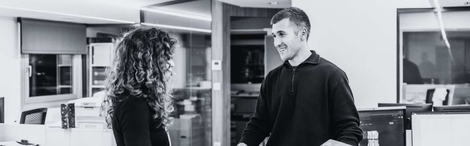 Managed print services benefits shown as two employees collaborate in a modern office